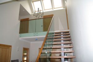 Designer contemporary oak central spine staircase with frameless glass balsutrade and inset oak handrails Aberdeen scotland1