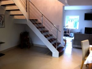 Designer open rise staircase with feature white steel strings and chestnut coloured beech treads and feature traversal rods and handrail cheshire1 e1471524776292